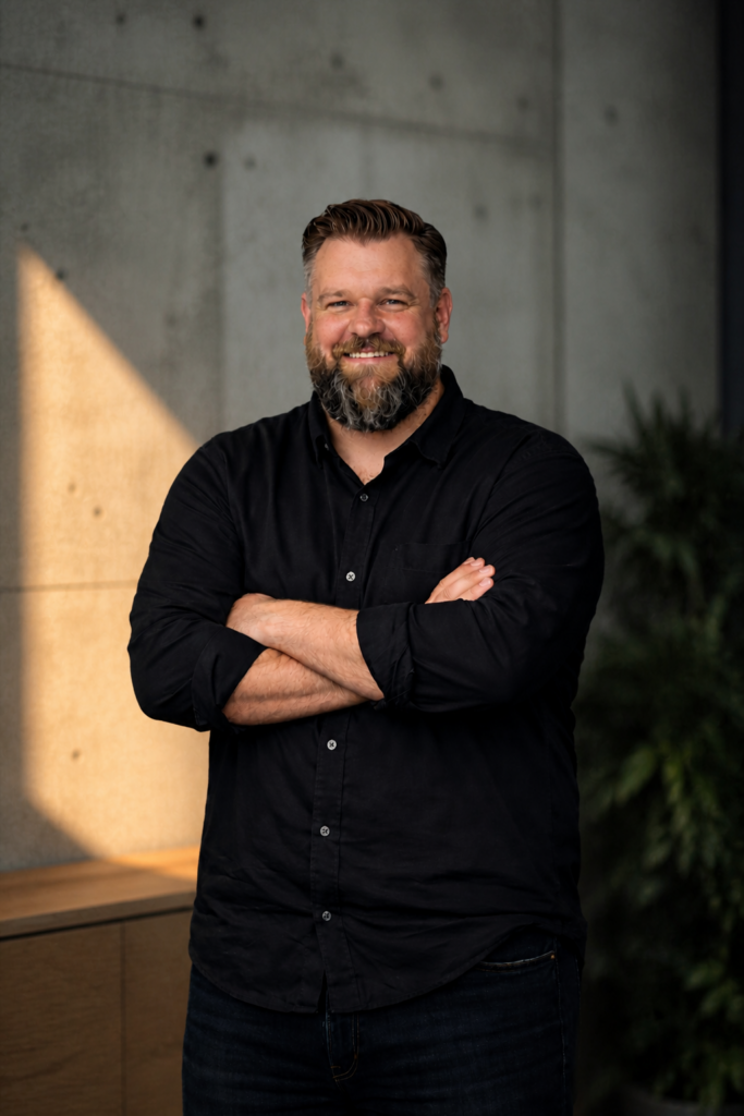 Porträt von Dennis Sand, Co-Founder von APPURION, vor neutralem Hintergrund.